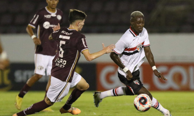 Jogador do São Paulo conduz a vola marcado por atleta da Ferroviária em jogo da Copinha