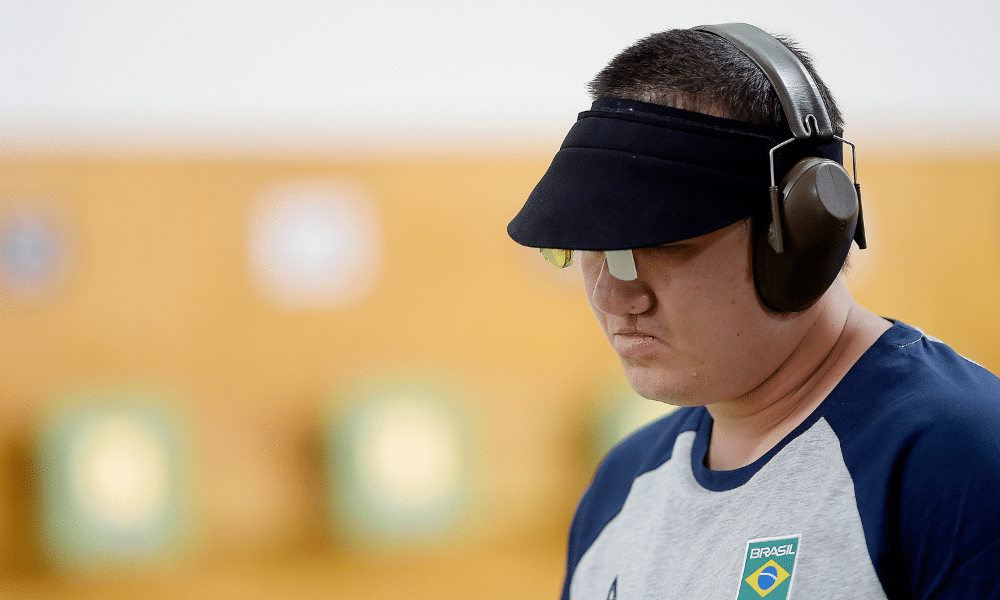 Felipe Wu, com viseira e fones de proteção, com cabeça abaixada cabisbaixo no Campeonato da Américas de tiro esportivo, em que ele não conseguiu vaga olímpica