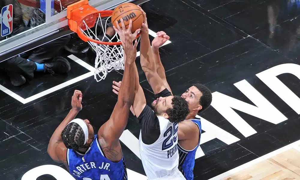 Na imagem, Mãozinha tentando enterrar no meio de dois adversários.