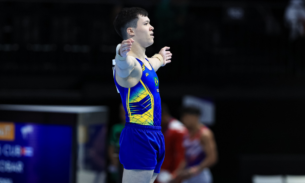Yuri Guimarães de braços abertos após acrobacia no solo na Copa do Mundo de Doha de ginástica artística, em que ele não conseguiu vaga olímpica