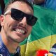 Na imagem, Kauê Willy em selfie com a bandeira do Brasil ao fundo.