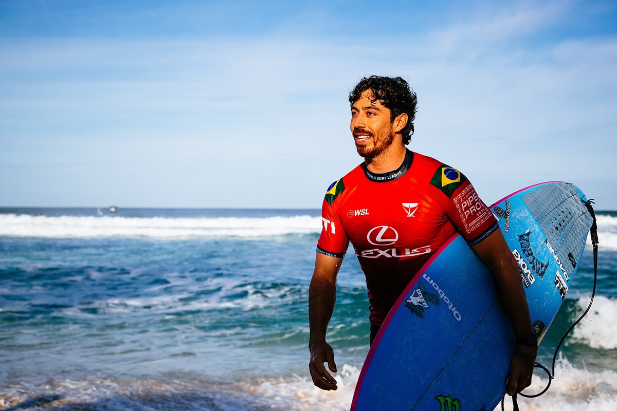 Na imagem, Yago Dora com sua prancha, após sair da bateria de ondas.