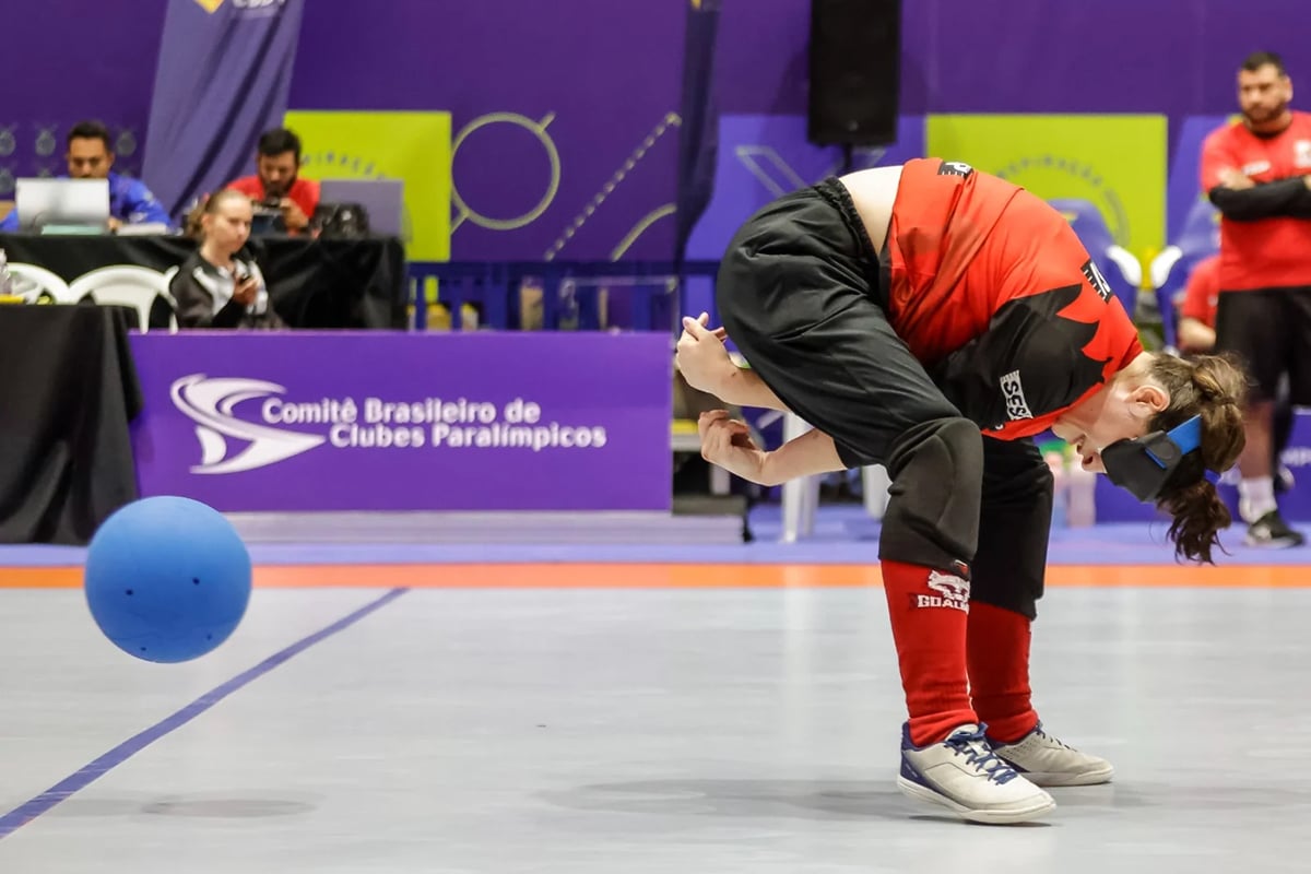 Na imagem, atleta do Sesi arremessando a bola de goalball em jogada por debaixo das pernas.