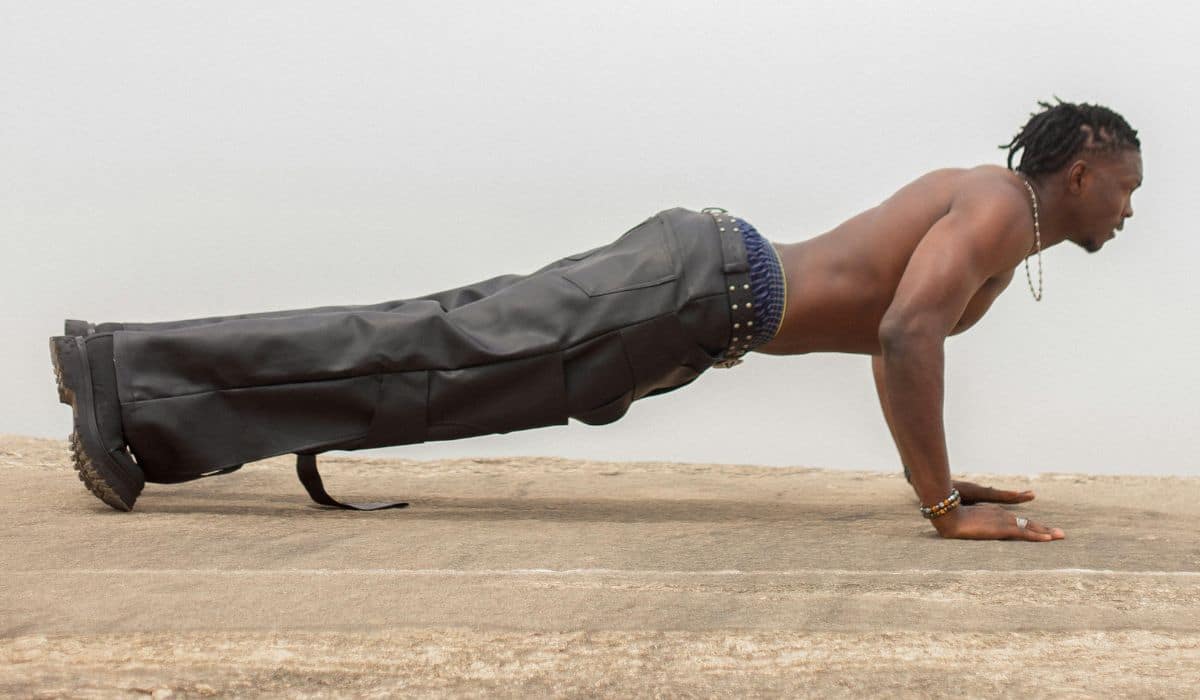 Pessoa realizando treino postural em casa para melhorar alinhamento corporal