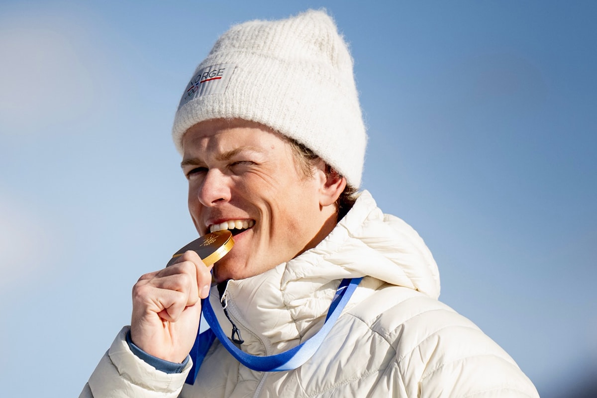 Na imagem, Johannes Klaebo, uma verdadeira lenda norueguesa, mordendo sua sexta medalha de ouro.