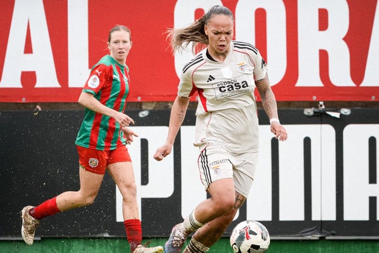 Na imagem, Nycole conduzindo a bola no campo com chuva.