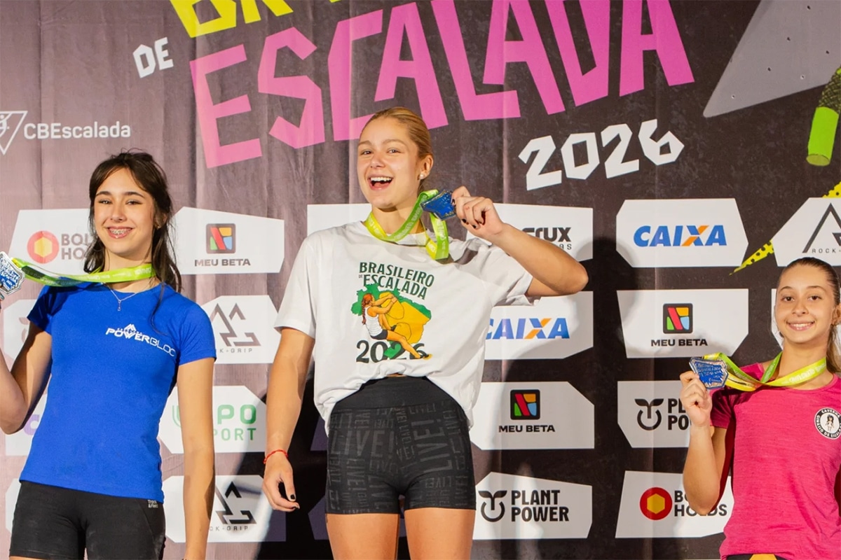 Na imagem, Mariana Hanggi com a felicidade de campeã, mostrando a medalha de ouro no pódio.