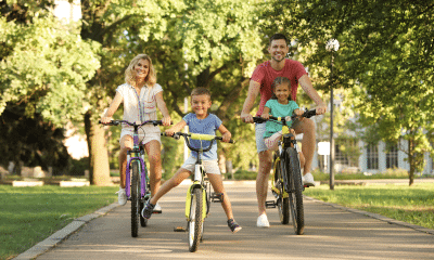 Pais e filhos caminhando, brincando em parque ou andando de bicicleta juntos, com clima leve e familiar.