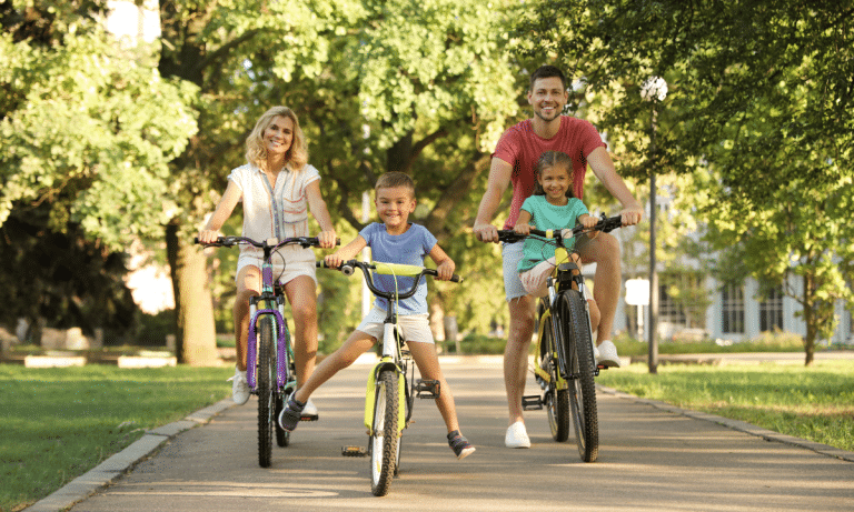 Pais e filhos caminhando, brincando em parque ou andando de bicicleta juntos, com clima leve e familiar.