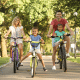 Pais e filhos caminhando, brincando em parque ou andando de bicicleta juntos, com clima leve e familiar.