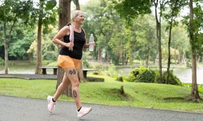 Pessoa caminhando em ritmo acelerado em parque, rua ou esteira, com postura ativa e sensação de energia no movimento
