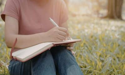 Pessoa sentada em ambiente tranquilo, escrevendo em um caderno ou respirando com calma após uma pausa na rotina.