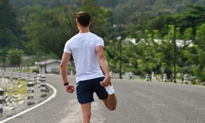 pessoa caminhando devagar na esteira ou ao ar livre após o treino, com expressão tranquila, toalha no ombro e ritmo leve
