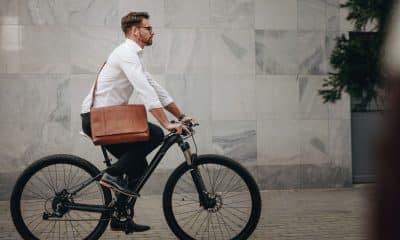 pessoa pedalando em ciclovia, em trajeto cotidiano, com clima de deslocamento para trabalho ou compromisso.