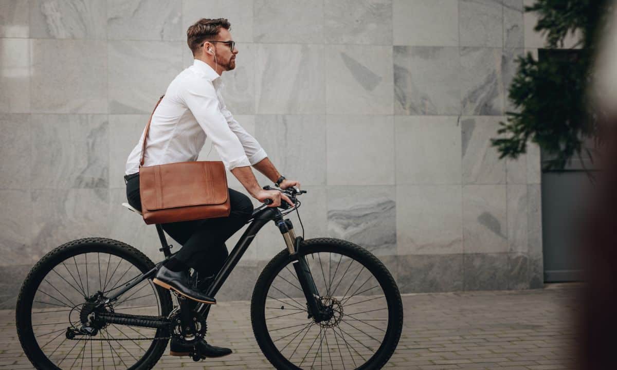 pessoa pedalando em ciclovia, em trajeto cotidiano, com clima de deslocamento para trabalho ou compromisso.