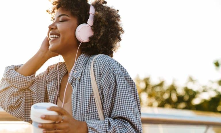 Pessoa ouve uma playlist com fones durante o treino na academia.