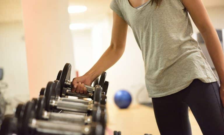 Pessoa registra carga e repetições durante treino de musculação