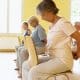 Pessoa com mais de 60 anos pratica yoga com apoio de uma cadeira