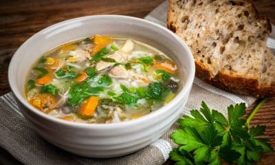 Tigela de sopa caseira com legumes, lentilha e frango servida no jantar.