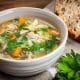 Tigela de sopa caseira com legumes, lentilha e frango servida no jantar.