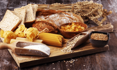 Mesa com arroz integral, pão integral, aveia e macarrão integral ao lado de refeição simples.