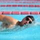 Pessoa nada crawl em piscina, virando a cabeça para respirar durante a braçada.