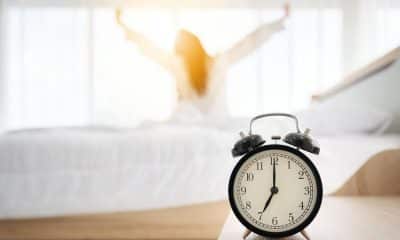 Pessoa acorda e olha para o despertador poucos minutos antes do alarme.