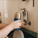 Garrafa reutilizável desmontada com tampa, canudo e escovas para limpeza.
