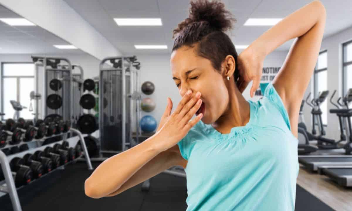 Pessoa boceja durante uma pausa entre exercícios na academia.