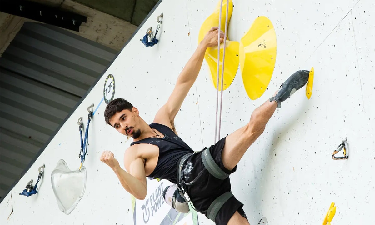 Na imagem, Davi Peres comemorando no alto da parede de escalada.