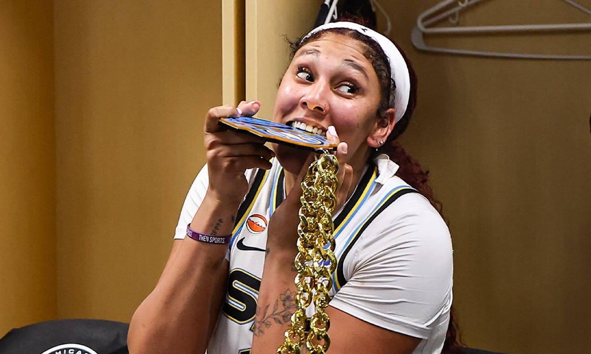 Na imagem, Kamilla Cardoso mordendo um medalhão de MVP do Chicago Sky.