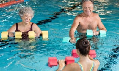 Pessoas com mais de 60 anos fazem hidroginástica em piscina rasa