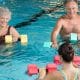 Pessoas com mais de 60 anos fazem hidroginástica em piscina rasa