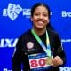 Na imagem, Maria Clara Araújo mostrando sua nova medalha dourada.