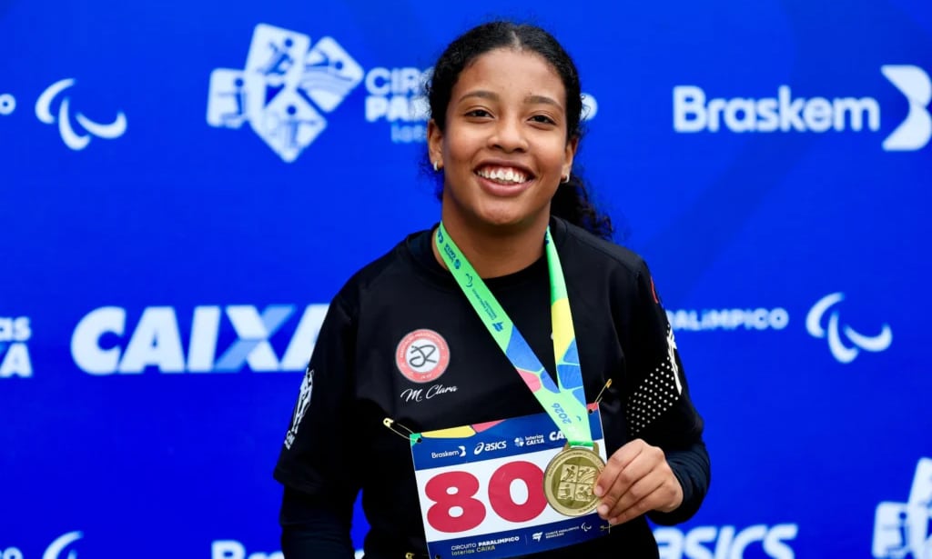 Na imagem, Maria Clara Araújo mostrando sua nova medalha dourada.